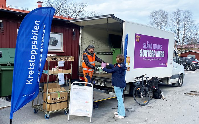 Kvinna lämnar produkter för återbruk till Kretsloppsbilen 