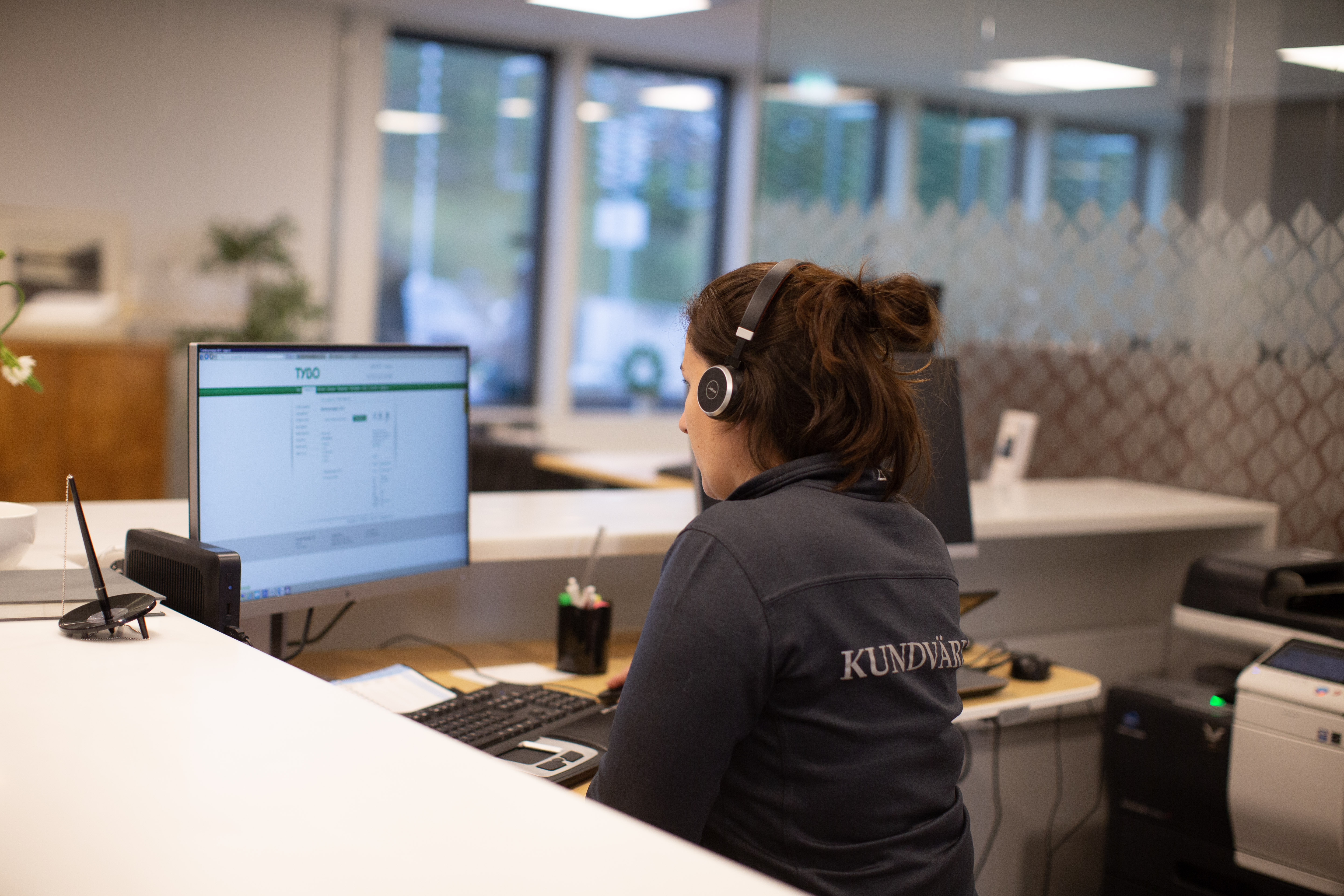 Bild på en av våra kundvärdar sittandes i vår reception.